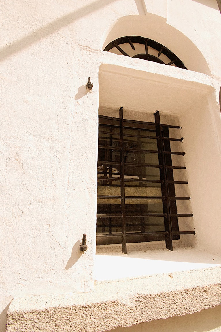 分厚い壁と鉄格子、建物上部には鉄条網と、刑務所の雰囲気がムンムン漂う。