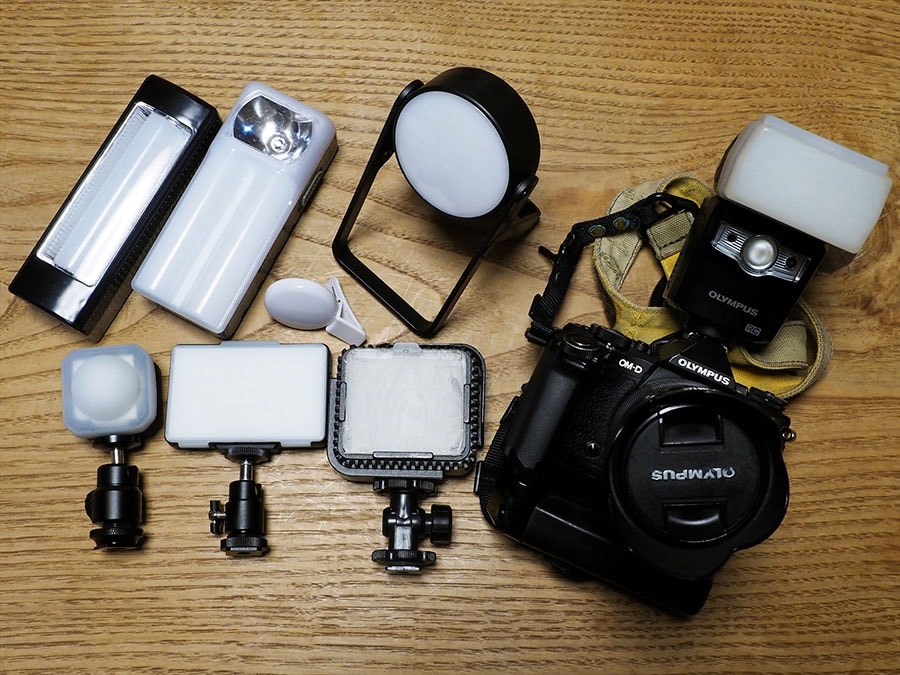 佐々木まことさんが普段使用しているフラッシュやLEDライト。左上は100円ショップなどで売られている、スマホライトとランタン。左下3台は、ムービー用LEDライト。右がデフューザー(拡散ボックス)を取り付けたフラッシュ。