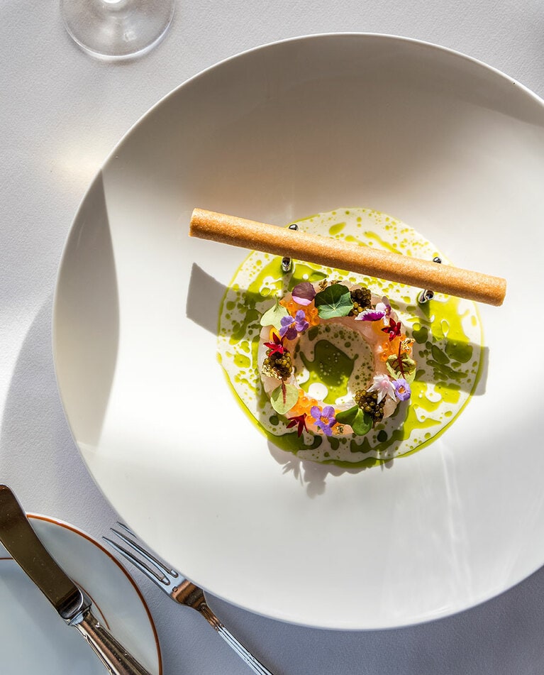 レストラン「ラ メール」の美しい一皿“ハワイ島産カンパチのタルタル フェンネルの冷製スープ バジルオイル クリスプシガール”。