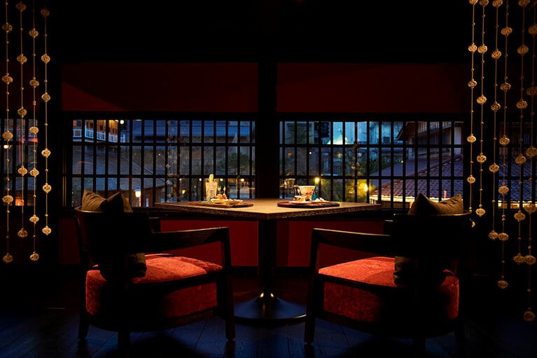 加賀の伝統的な建築手法である紅殻色の格子越しに、開湯1300年の歴史を有する山代温泉の街並みを一望する。