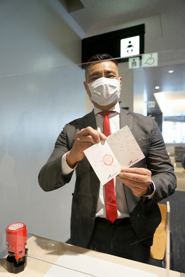 模擬出国カウンターで出国スタンプを押してもらった！　出国スタンプを押してくださったこの方、実はシンガポール政府観光局のマーカス・タン北アジア局長だ。