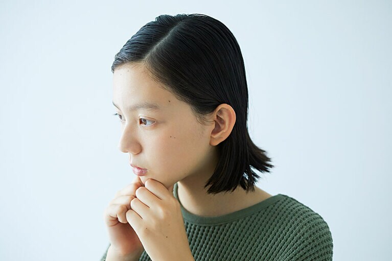STEP1 フェイスラインを引き上げる。両手の親指の腹と人差し指であごを挟む。親指で圧をかけながら、フェイスラインに沿って、耳の下まで手をすべらせて、引き上げる。これを3回繰り返す。