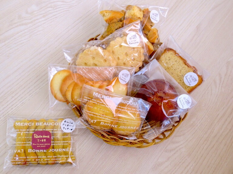 バスケット内、上より時計回りに「スコーンラスク」328円、「ラム酒ケーキ」270円、「焦がしバターフィナンシェ プレーン」291円、「塩サブレ」184円、「ラングドシャ」238円、「ショートブレッド」270円。左下「わんこクッキー」280円。※全てテイクアウト価格。