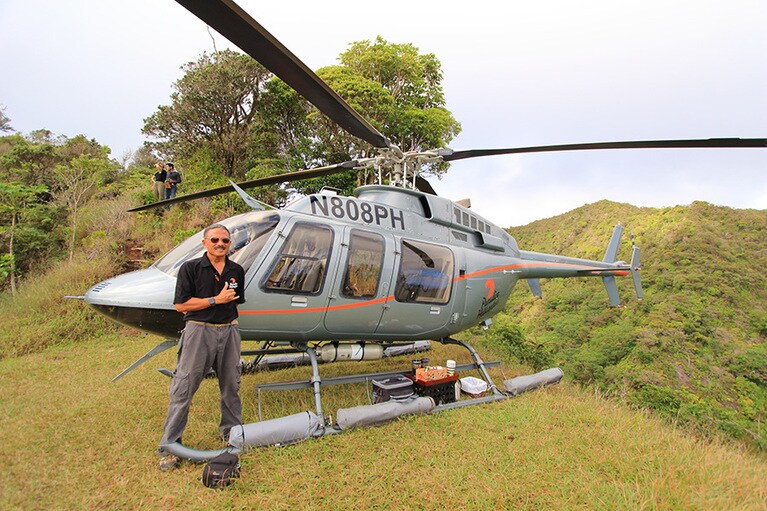 山の尾根でコーヒーとお菓子をいただく。実はここ、かなり幅が狭い。ヘリコプターの足のすぐ後ろは絶壁、写真左側にはもう片方の絶壁が見えている。ピンポイントで着地する技に、ツアー参加者からは歓声が上がった。