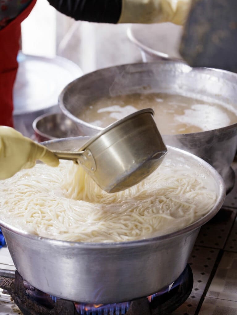 大鍋で麵をゆでる。奥には香りのいい出汁が。