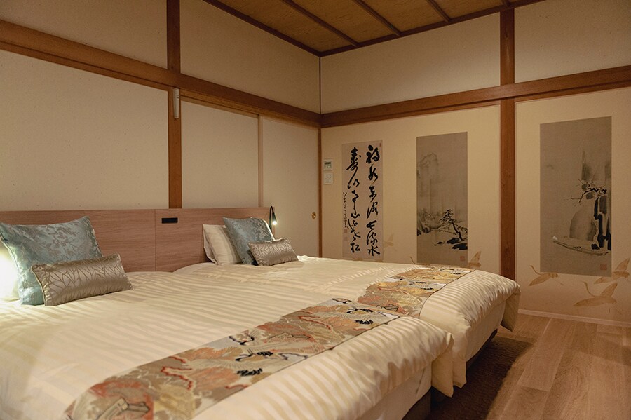 貴賓室の上品なベッドルーム。日本画が描かれた壁や襖が趣深く、部屋から美しい庭園を望めます。