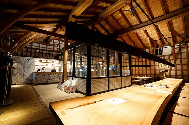 壁に沿って大きなテーブルが並び、その中央ではビールが造られている。