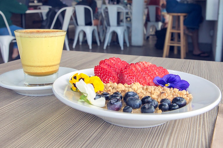 手作りヨーグルトとグラノーラ＆フルーツ 7.95ドル、スパイス尽くしのターメリックラテ 4.25ドル。