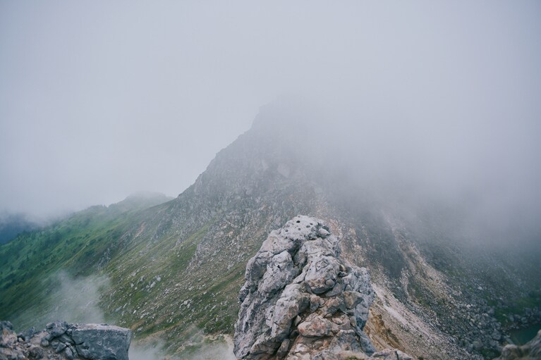 霞が山肌一面を幻想的に覆い、火山ならではの荒涼とした風景を際立たせる。
