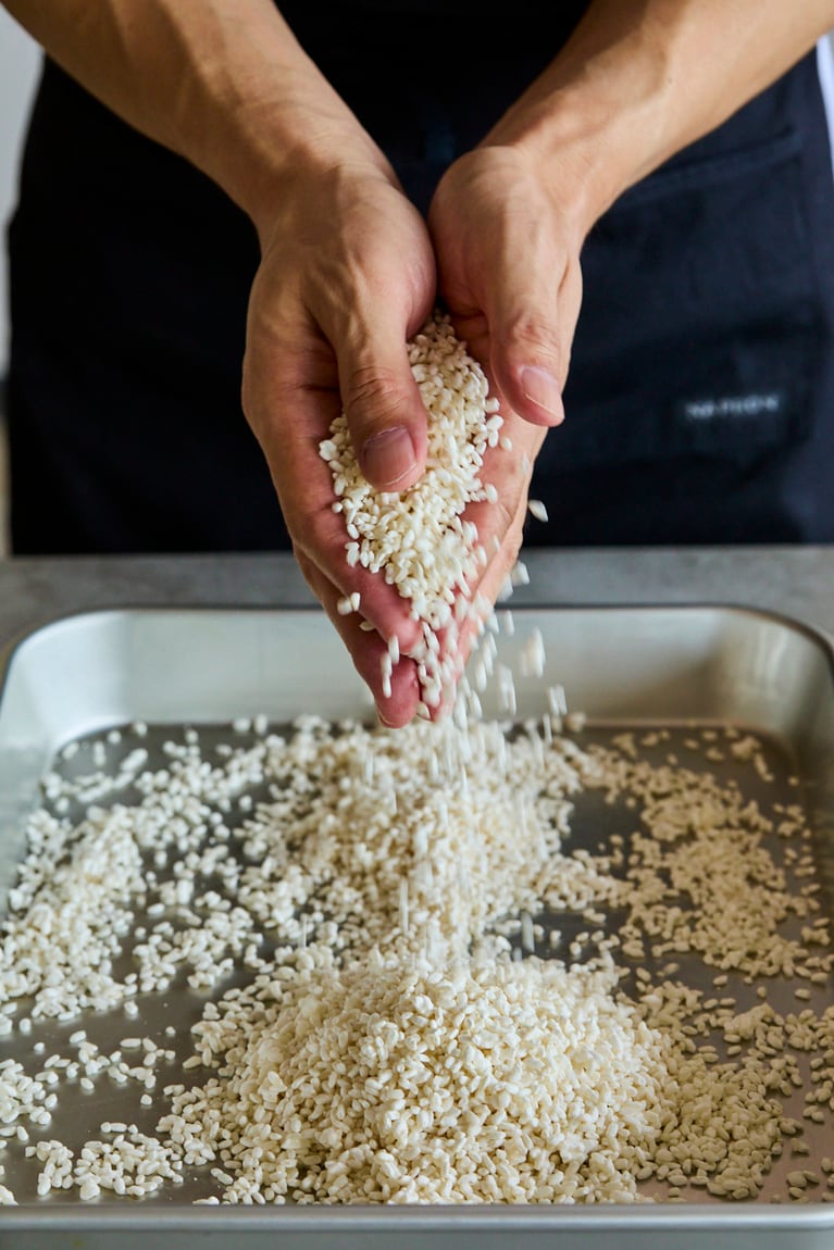 両手をこすりあわせて、麹をバラバラにする。撮影／寺澤太郎　『麹づくりと発酵しごと』より