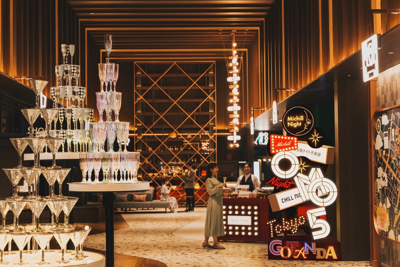 「OMOベース」のネオンやシャンパンタワーなどの華やかな装飾で、五反田という街の魅力を表現している。