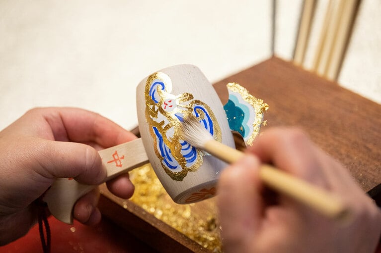 筆でやさしく表面を撫でながら余分な金箔を落として仕上げる。