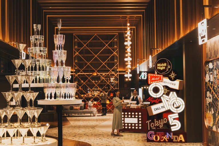 「OMOベース」のネオンやシャンパンタワーなどの華やかな装飾で、五反田という街の魅力を表現している。