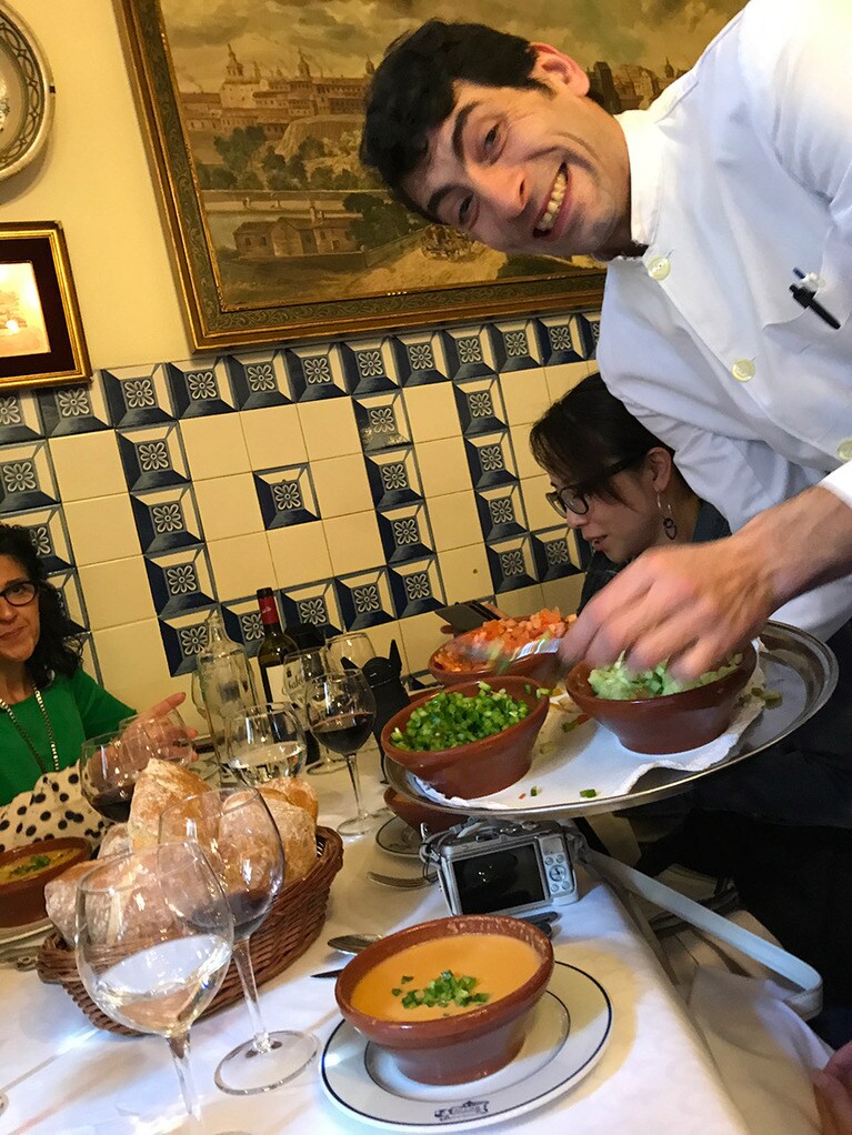 トマトベースの魚介スープのトッピングは、好きなものを好きな量で、この笑顔とともに。