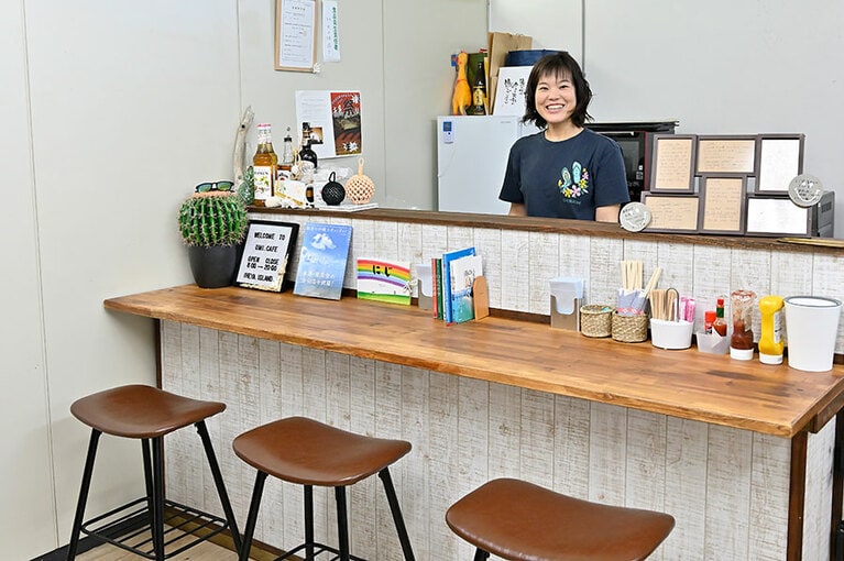 「umi cafe」店主の大久保苑子さん。店内には「そよかぜレンタカー」のカウンターも。