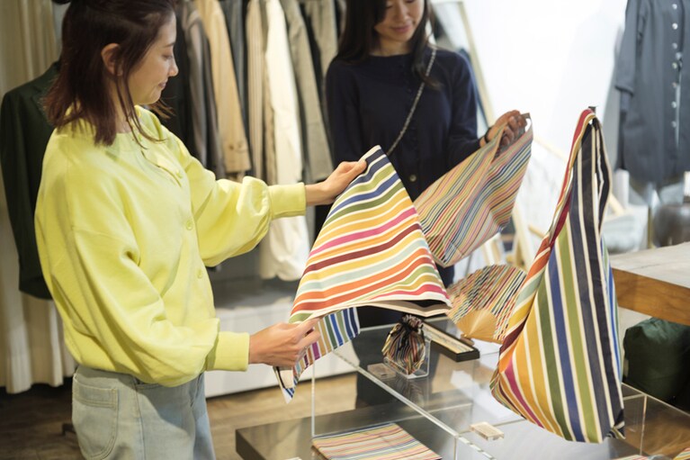 最近人気を呼んでいるカラフルな「SDGsシリーズ」を手に、二人はあれこれお土産選び。