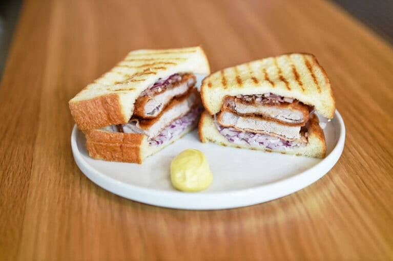 「カツサンド」1,100円。二枚のカツと紫タマネギがはさまれた人気のカツサンド。ギムレットハイボールを合わせるのがおすすめ。こちらは14:00～のメニュー。夜になると、さらに進化した『夜カツサンド』も登場。