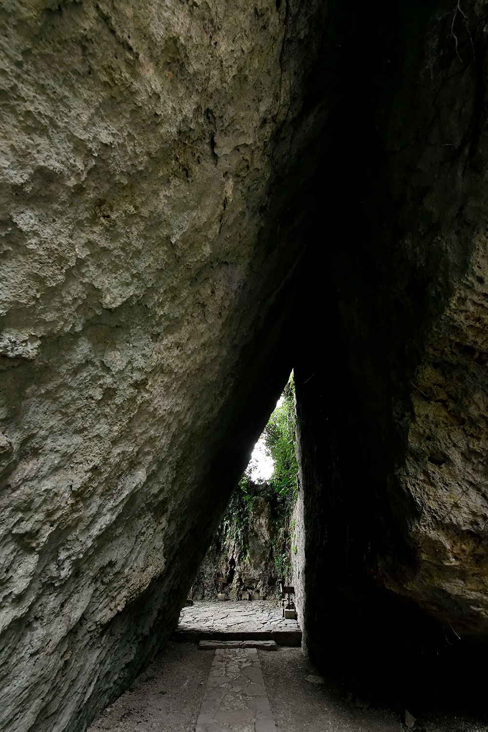 大きな岩が支え合うように切り立つ斎場御嶽の最奥部。奥に小さく開けた場所が拝所の三庫理(サングーイ)。