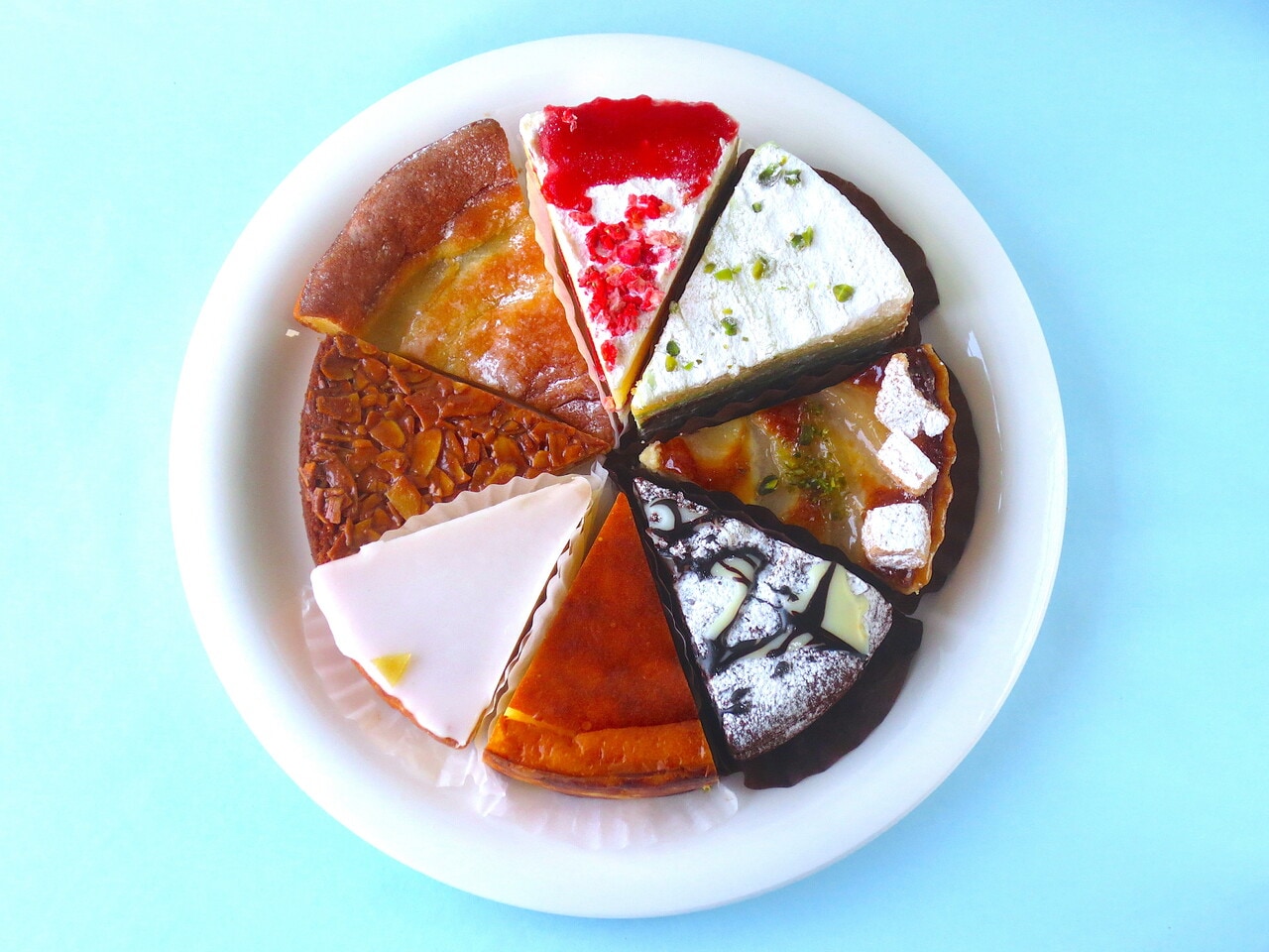 上から時計回りに「ビクトリアケーキ」400円、「ピスタチオナッツバーム」450円、「洋梨のタルト」450円、「クラシックショコラ」450円、「バスクチーズ」480円、「ガトーナンテ」430円、蜂蜜アーモンドクッキー「フロランタン」350円、「ファーブルトンヌ」190円。
