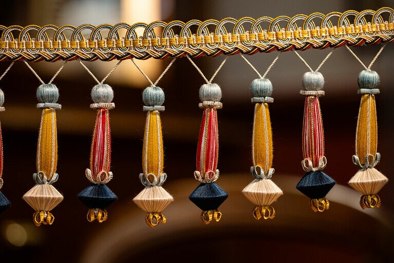 カーテンの一部となるフリンジを奥の工房で展示している。