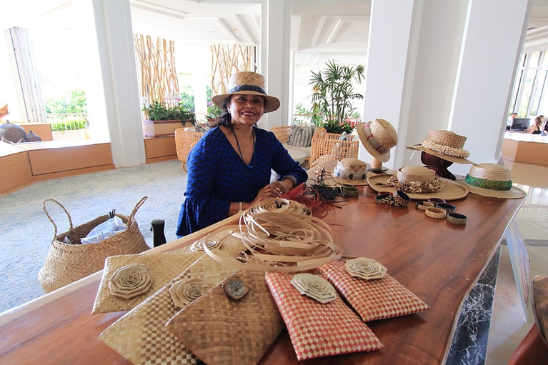 帽子がお似合いのアロマ・ワン先生。テーブルの上にあるものはすべて先生が作ったラウハラ織り製品。