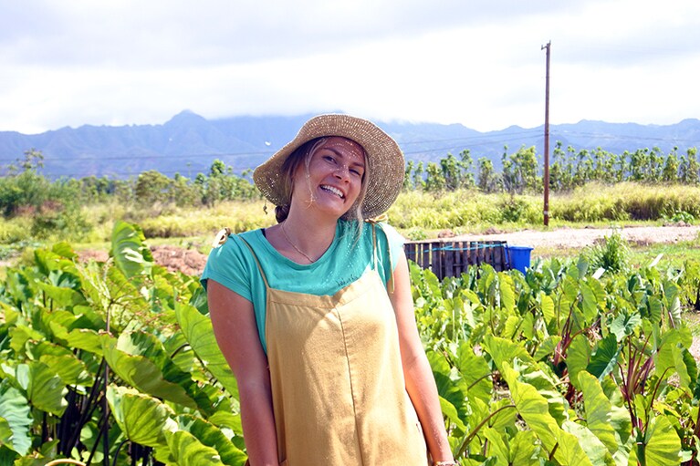 ナチュラルなおしゃれがステキなコクア・ハワイ財団のスタッフ、ナタリーさん。ジェネラルストアの背後にはタロイモなどの畑が広がっています。
