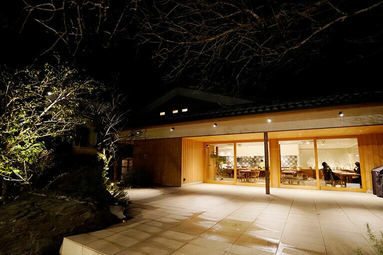 大きな窓が印象的。お店を囲む木々は古民家だった頃の面影を残している。