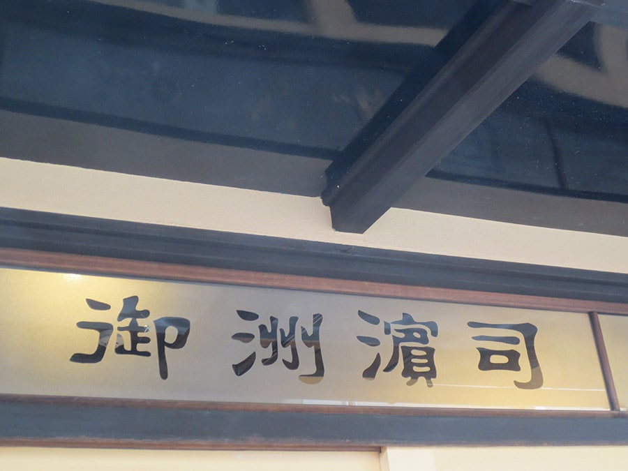 扉の上の磨りガラスには「御洲濱司」の文字。