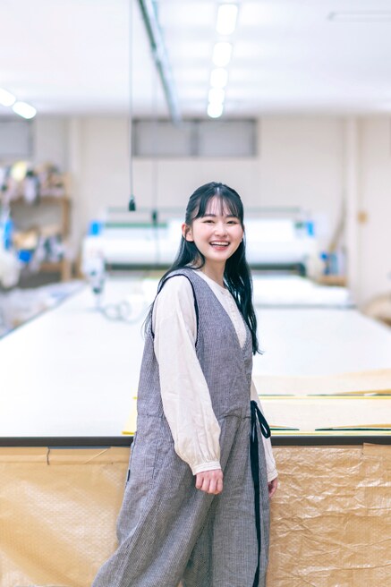 ゆったりとしたフォルムのオーバーオールとブラウスを合わせて着用した山田さん。私服でも着心地のよいルーズシルエットのパンツを好んで穿いているそう。リネン天然染めギャザーブラウス（OFF WHITE）30,800円、［UpcycleLino］ギンガムアシメサロペット（CHECK）37,400円／ネストローブ