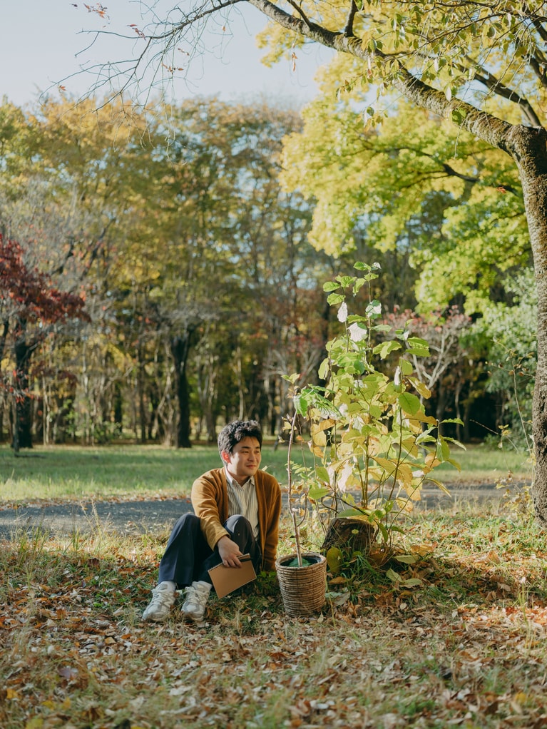 『外と』に出演するラテンアメリカ映画の研究者でもある新谷和輝と鉢植え。植物は以前からの金子のモチーフのひとつだ。