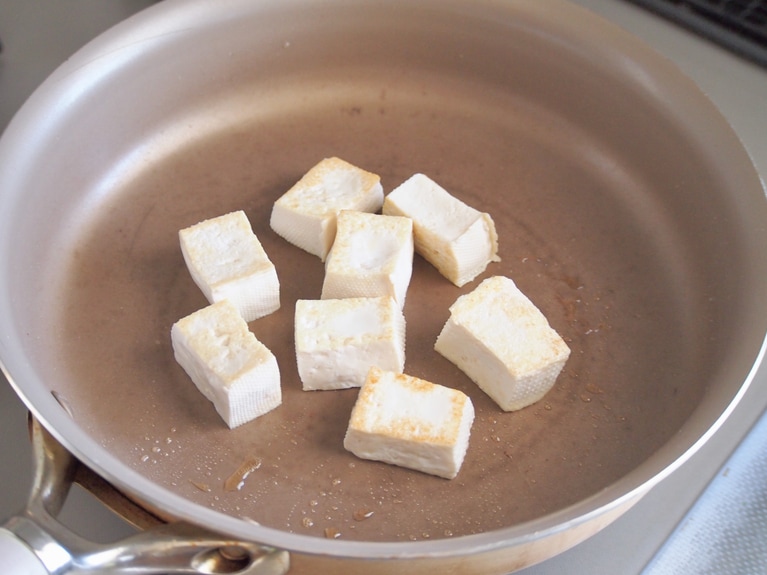 フライパンを温め、ごま油をしいたら、（3）の豆腐を入れる。表面に焼き色がつくまでじっくり焼く。