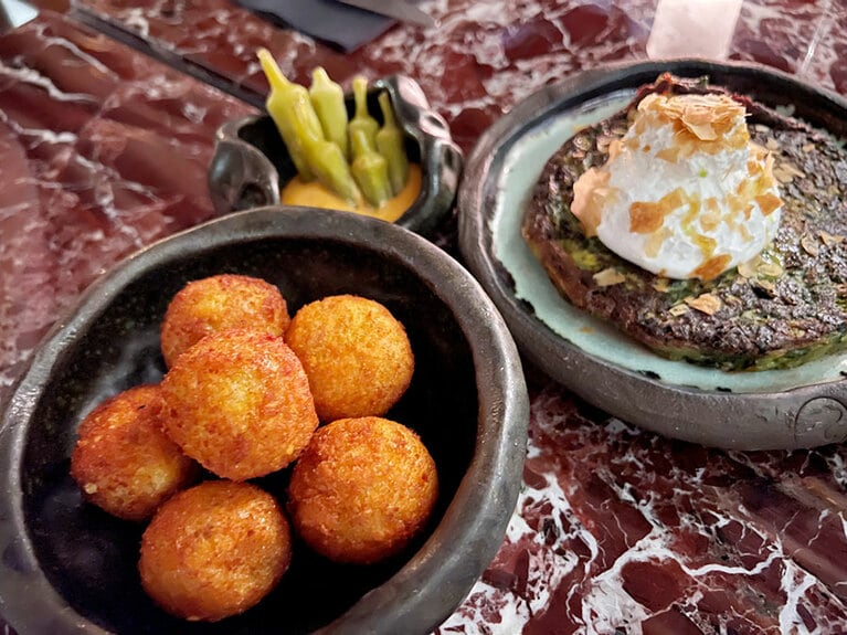 コロッケとサワークリームを載せたハンバーグ。スパイスの効いたハンバーグはこの店の人気メニューだ。