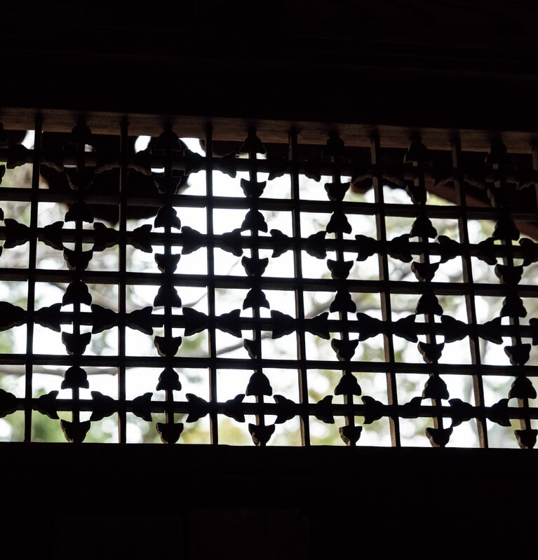 玄関上部に施された透かし彫りの繊細な装飾が、空間の格調を高める。