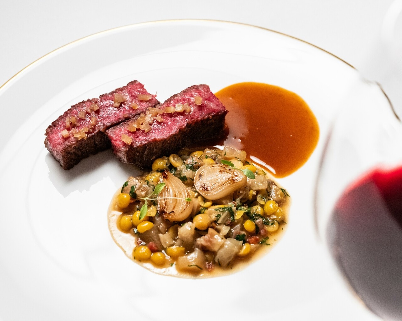 「和牛サーロイン 仔牛の足とひよこ豆の煮込み ペッパーソース」。ペアリングの赤ワインは、ポルトガル北部の銘醸地ドウロの自然派「CARME」。