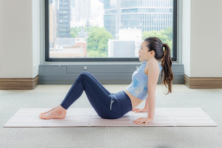 息を吸って背筋を伸ばしてから、吐く息とともに背中と腰を丸めて胸を引き下げる。
