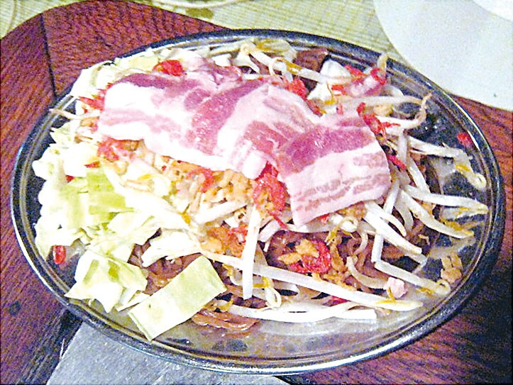 皿を被せて蒸し焼きにする（2012年撮影）。