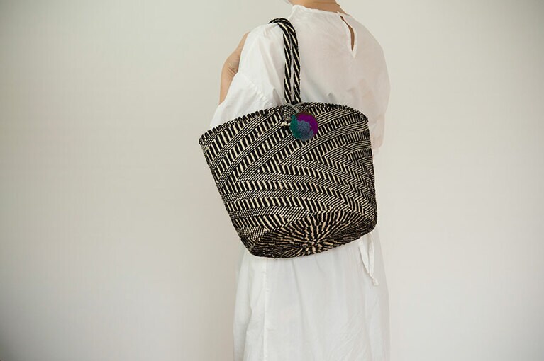 ラフな白ワンピでも、黒色の入ったかごバッグならリゾート感を抑えられる。