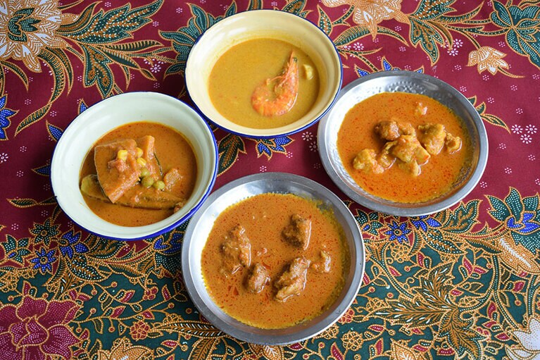 左から時計回りに、ベジタブルカレー、シーフードカレー、チキンカレー、ビーフカレー。4種のカレーは、具の種類だけでなく、使うスパイスやカレーのとろみ、味もそれぞれ違い、まったく別のカレーになっている。