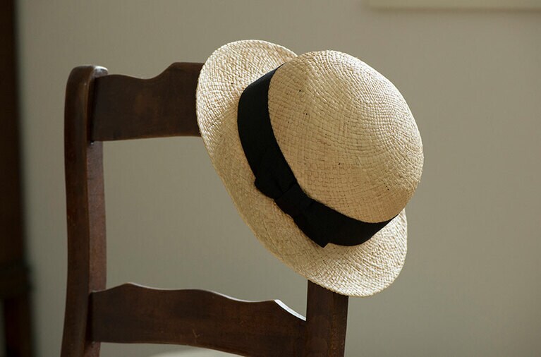 かわいらしいデザインの麦わら帽子、黒いリボンをあしらって大人っぽく。