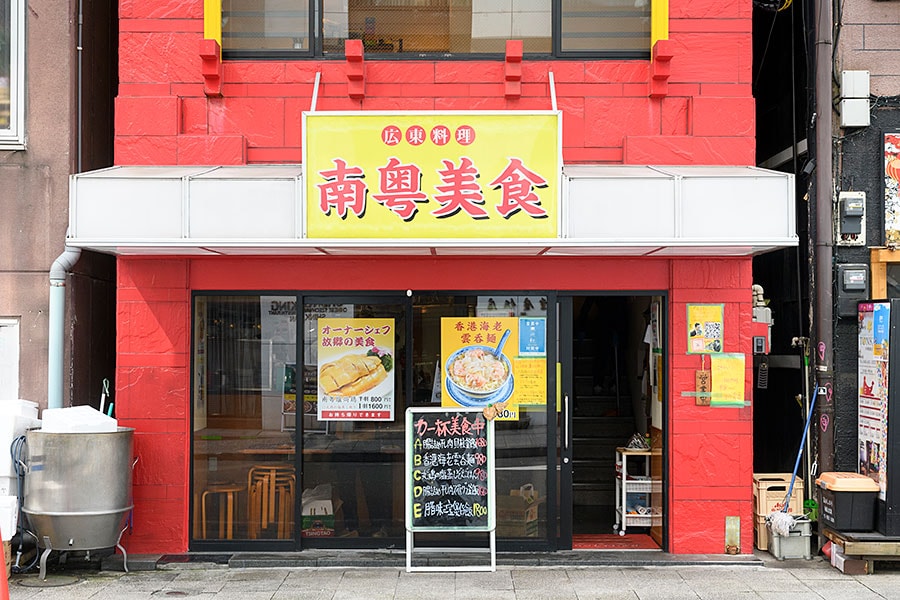 赤い壁に、黄色い大きな看板が眩しい外観。1階と2階が「南粤美食」。