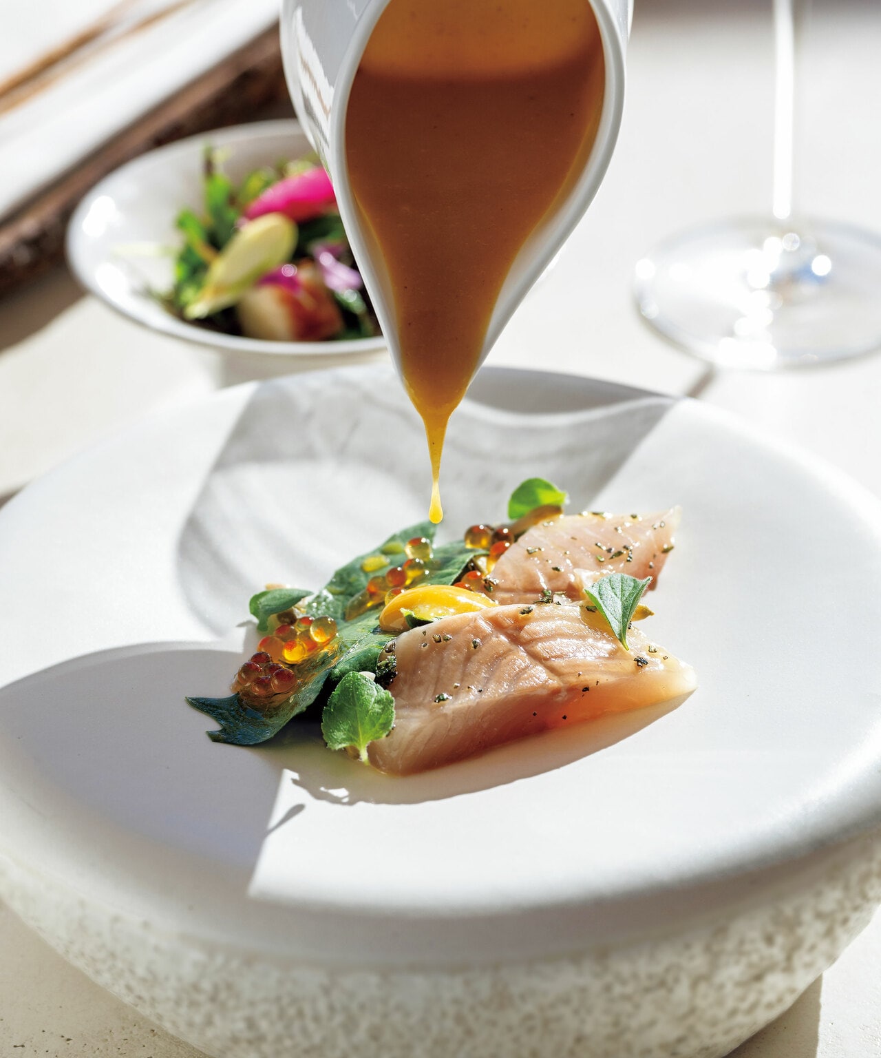 甘みのあるニジマスに発酵黄梅のソースをかけた「オルト」のシグネチャーコースの一皿。ハーブや野菜は店の菜園で採れたもの。