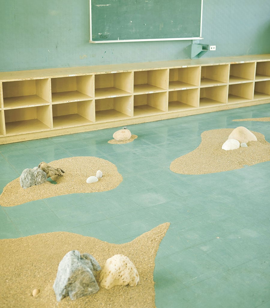 染谷 聡氏の作品が展示されている空間。青みがかった教室の床に、砂と岩を点在させることで、まるで海のような情景を作り出すことに成功している。