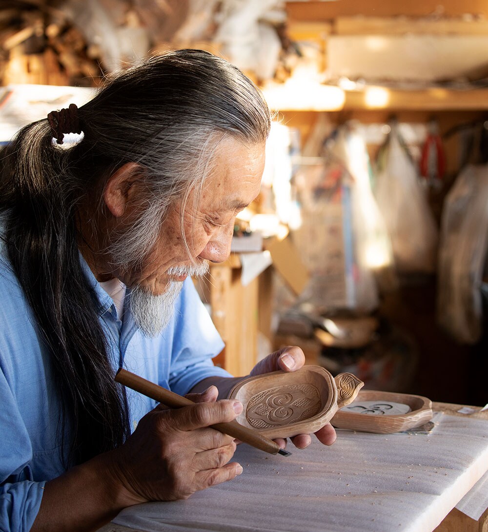 高野繁廣さんは東京出身。北海道無銭旅行の途中、二風谷でアイヌの木彫に出会って以来この地で暮らし、約半世紀の作家歴をもつ。