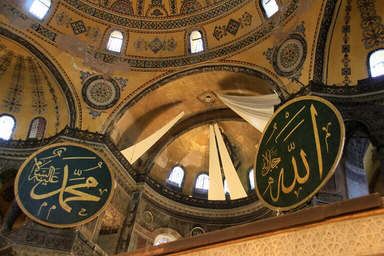 お祈りの場の上に描かれたキリスト教のフレスコ画は、白い布で覆われている。