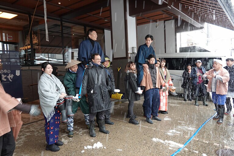 旅館を出発する2組の「むこ」と新妻。