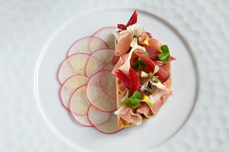 “甲州ワイン豚の自家製生ハムと地元産ルバーブのタルトレット”。熟成期間が終わる自家製の生ハムを切り始める夏から秋まで、生ハムを使った料理が楽しめる。