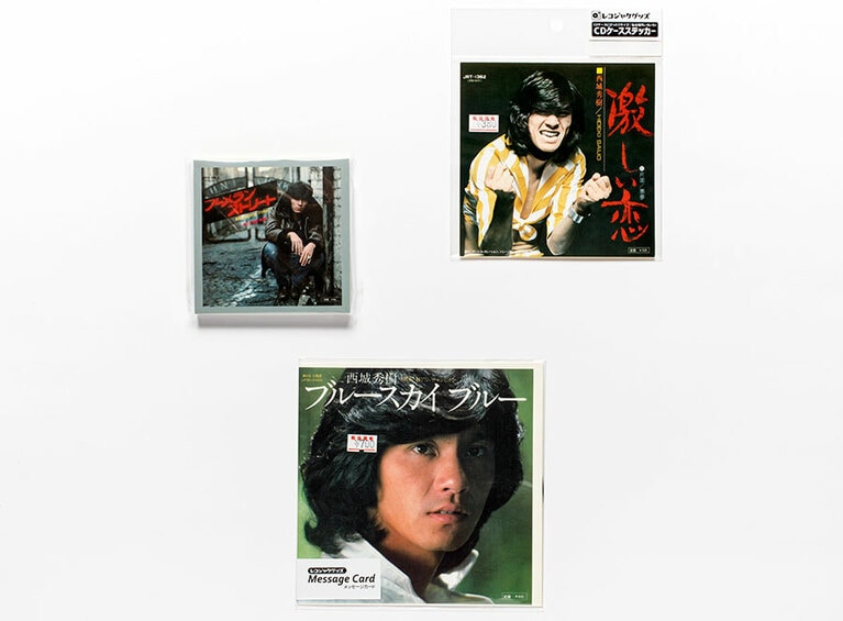 まんまと買ってしまった、左から反時計まわりに西城秀樹のメモ帳、レコード型メッセージカード、そしてCDケースステッカー。このカッコよさである。誰が散財した私を責められようか。