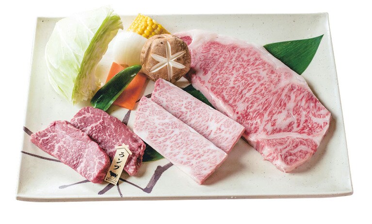 飛騨牛セット(2～3人前) 5,800円。右上から、焼肉用の牛カルビの切れ端をつかったカルビチャーハン。その日入った良質な部位が選ばれる本日のしもふり。写真はトモサンカクとも呼ばれる「ヒウチ」。飛騨牛セットは2～3人前のボリュームで大満足。超肉厚の極上タンも、人気メニューのひとつ。