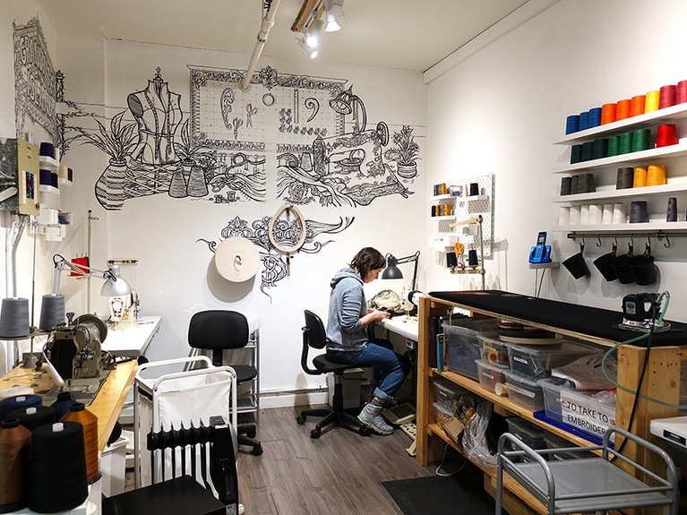 様々な道具に囲まれて作業をするスタッフ。