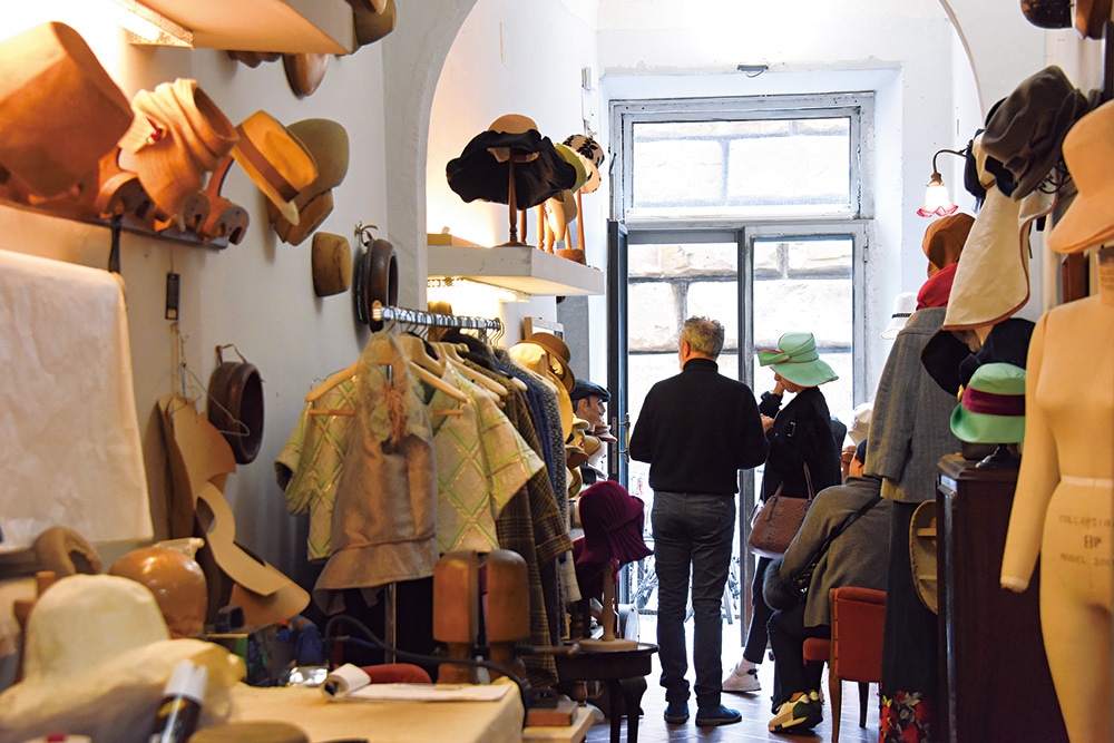 素材やスタイルがそれぞれに異なるたくさんの帽子が並ぶ店内。ラックに並ぶ洋服も実はガット氏が作ったもの。